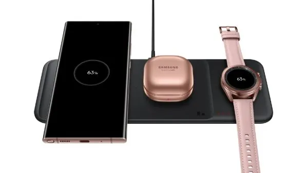 Base negra Samsung Wireless Charger Trio con un teléfono, un estuche de auriculares y un reloj sobre sus tres zonas
