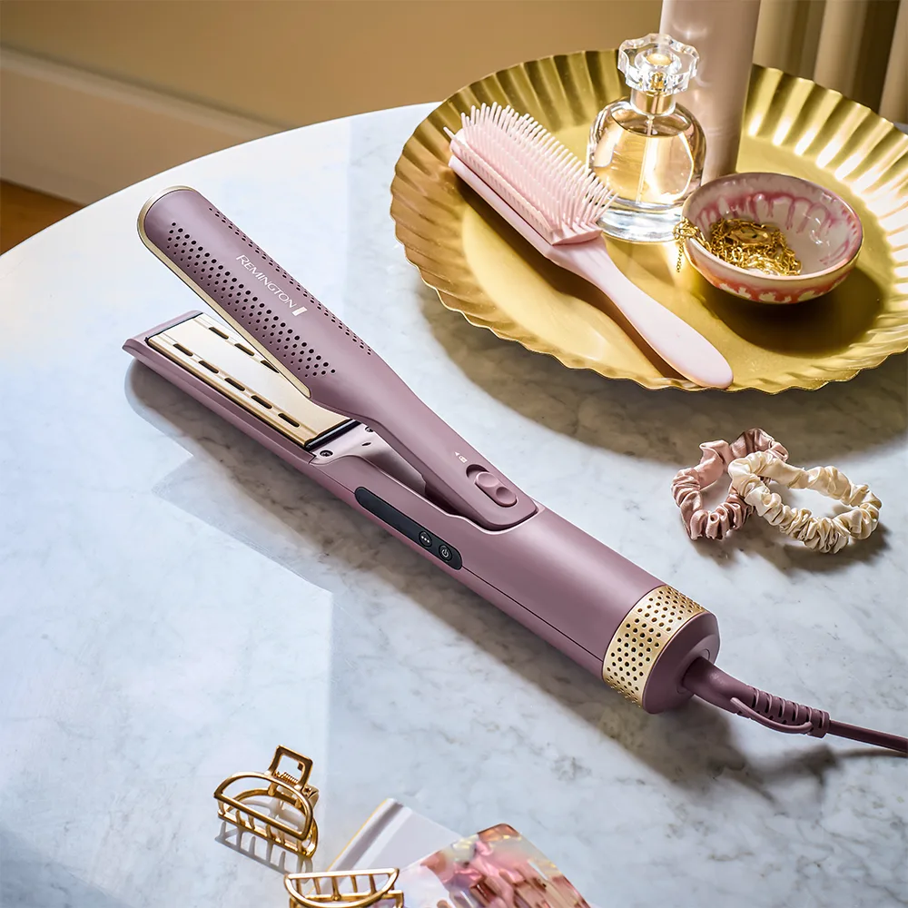 Estilizador Remington alargado y articulado de color malva con detalles dorados, placas con ranuras, botones y cable de alimentación. - Vista 2