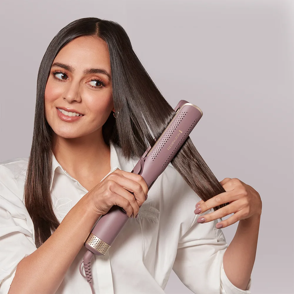 Estilizador Remington alargado y articulado de color malva con detalles dorados, placas con ranuras, botones y cable de alimentación. - Vista 3