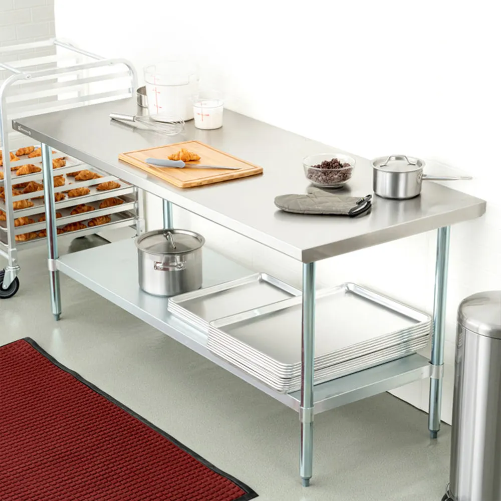 Mesa de trabajo rectangular de acabado metálico plateado, con superficie plana, estante inferior y cuatro patas, sin respaldo. - Vista 2