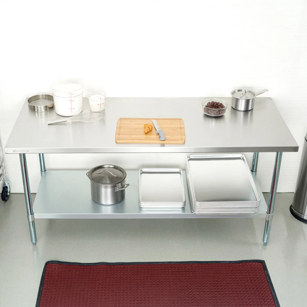 Mesa de trabajo rectangular de acabado metálico plateado, con superficie plana, estante inferior y cuatro patas, sin respaldo. - Vista 3
