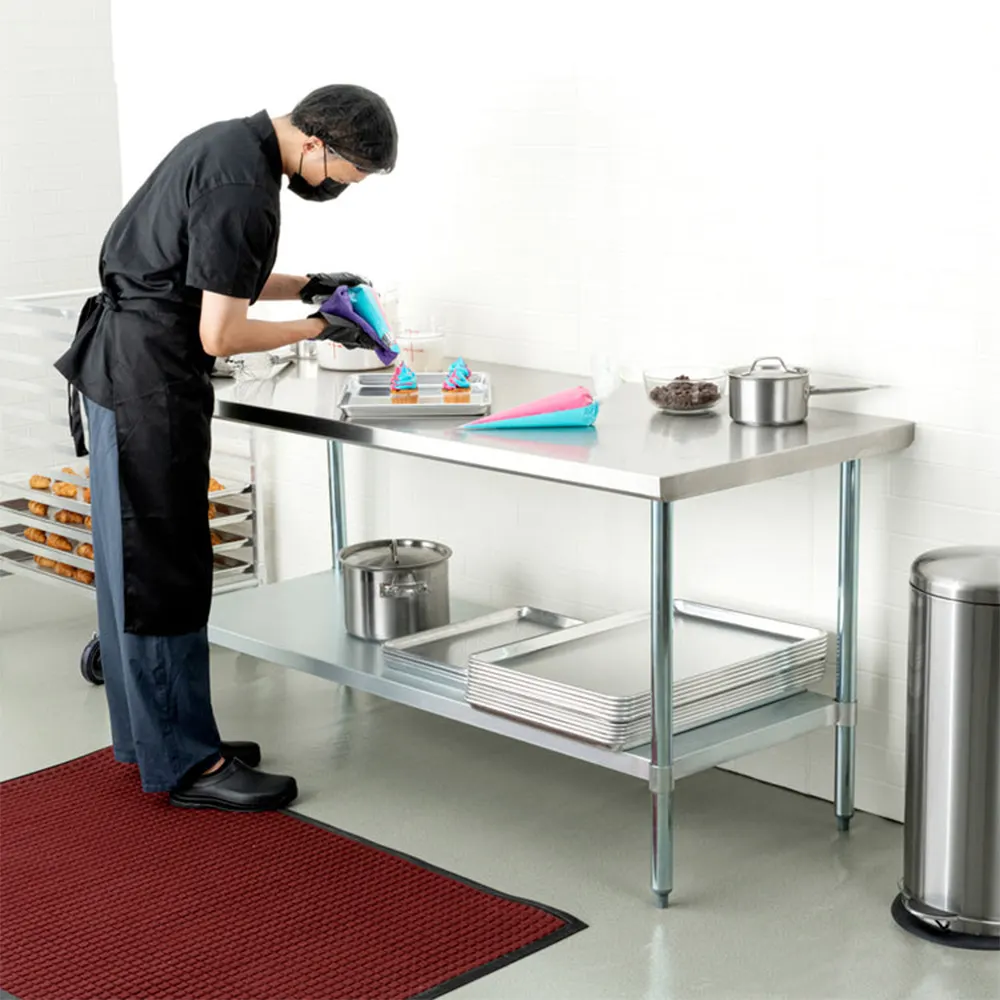 Mesa de trabajo rectangular de acabado metálico plateado, con superficie superior plana, estante inferior y cuatro patas, sin respaldo. - Vista 3